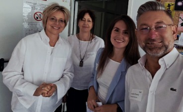 Willkommen im BTZ-Neuro Kamen! Foto: Vier Personen stehen nebeneinander und lachen in die Kamera.