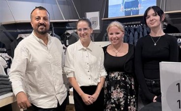 Teilnehmende mit Ihrem Ausbilder Drei Teilnehmende stehen gemeinsam mit ihrem Ausbilder im Ladengeschäft